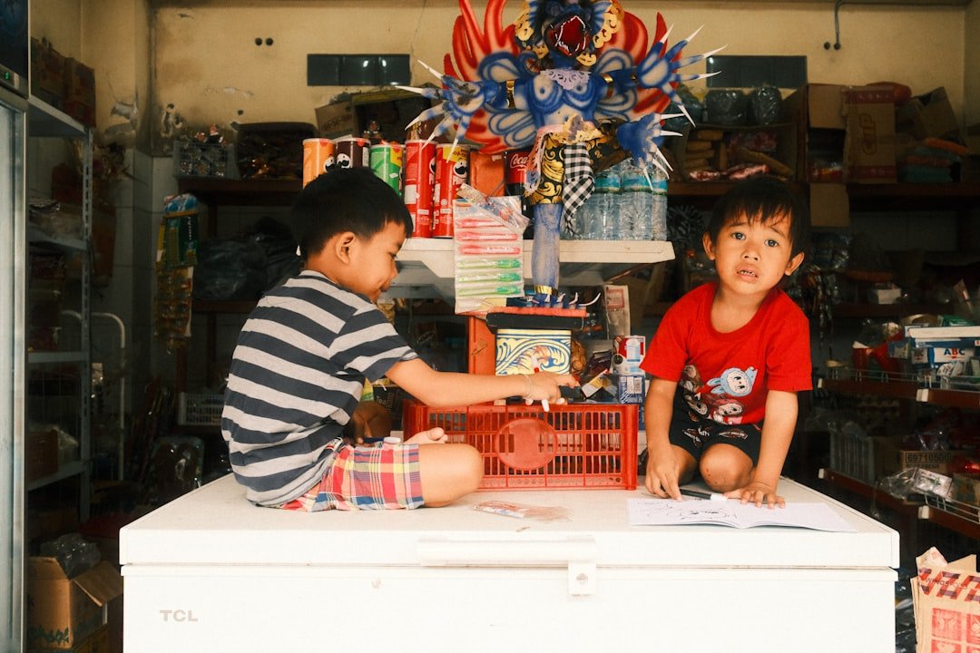 Children sitting at a table doing crafts with recycled materials like cardboard tubes, egg cartons, and newspapers